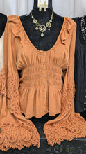 Load image into Gallery viewer, This beautiful contemporary blouse will become one of your favorites, you&#39;ll want one in every color offered. It features a ruffled neck line, smocked front with button closures, and long crochet bell sleeves. 