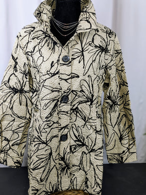 Lightweight beige jacket with an abstract flower outline design. There is a crushed, or crinkled design in the fabric. It has a bendable wire in the neckline so the garment will keep it's shape after washings. 