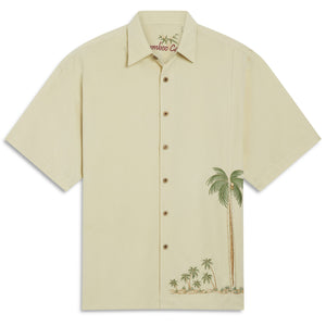 Here is a simple cream colored button down camp shirt. It has an embroidered palm tree accent on the front left lower left hem area. It's a very detailed scene of palm trees that is done in a classic and classy manner. This shirt could be worn dress casual, as a golf shirt or as an adult styled Hawaiian shirt. This is a classically done shirt that is stylish and comfortable.