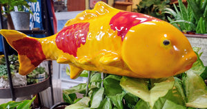 Orange ceramic koi fish with red dots on metal post