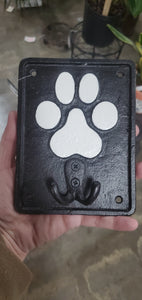 black cast iron wall hook with a white paw print and double hook