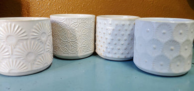 classic adorable mini ceramic planters with drainage holes and plugs. Contemporary embossed designs.