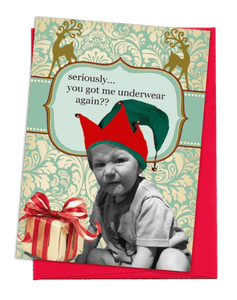 GREETING CARD | BRIGHT, CHRISTMAS-RED ENVELOPE. | TEAL WITH WHITE FLORAL BEHIND/TEAL STRIPE ACROSS AND 2 FANCY, TAN DEER ON TOP | YOUNG BOY WITH SHORT-SLEEVED SHIRT AND SHORTS/MAKING UGLY FACE/WHITE CHRISTMAS PRESENT WITH RED AND GOLD RIBBON | WORDS: OUTSIDE, “SERIOUSLY…YOU GOT ME UNDERWEAR AGAIN??” INSIDE, “…MAY ALL YOUR HOLIDAY WISHES COME TRUE…”