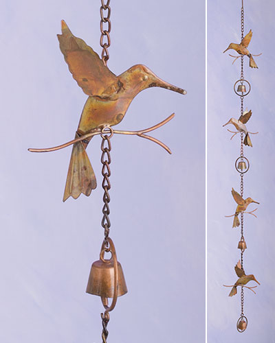 Copper metal rain chain with cut out hummingbirds  in between bells with a metal circle around the bells.  There is a bell at the bottom of the rain chain.  