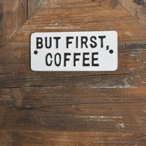 Cast Iron But First Coffee sign.  White background with black raised letters.  Two holes on each side to hang sign.  could be inside or outside.