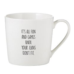 White coffee cup that reads "It's all fun and games until your jeans don't fit."