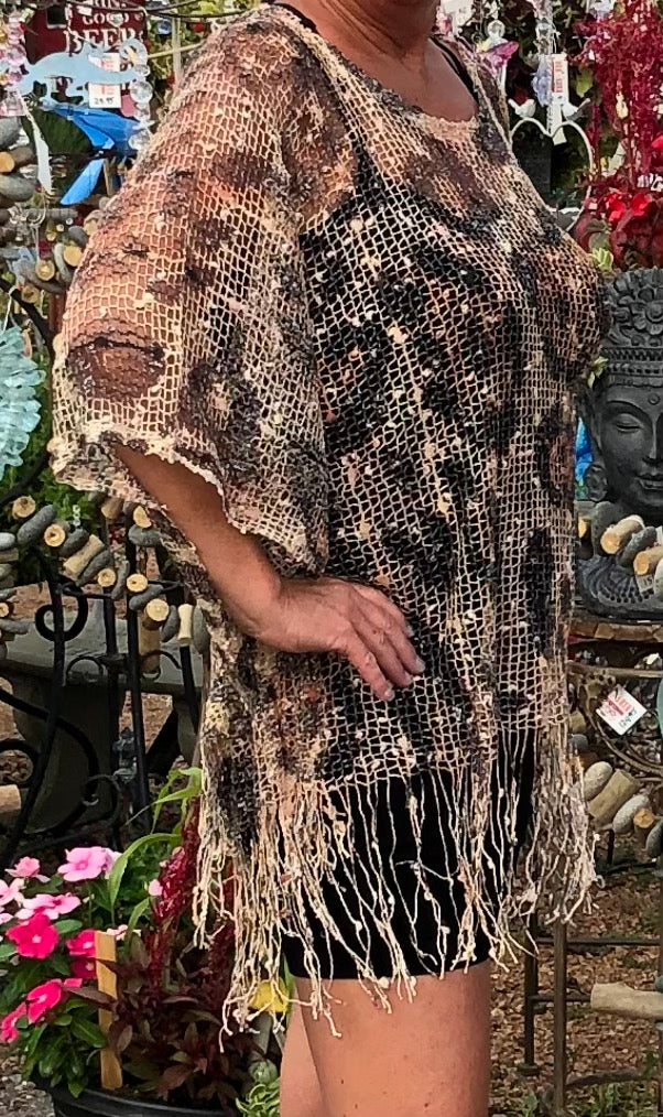 Crocheted shawl with fringed waistline.   Scoop neck.  Side seams.  Slips over your head.  