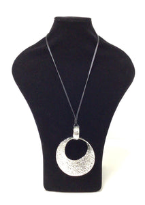 Metal 4"x3" mottled mobius circle pendant. The pendant hangs on 16"'s of two smooth strands of black braided cord and there is a clasp that can add approximately 1.75" if needed, however it can easily slip over the head. 