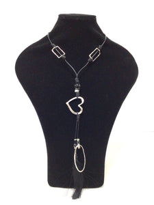 A modern, stylish necklace.  Pendant features an open heart, an elongated oval and a black silklike tassel. There are two 1.25"L open rectangles that adorn the black leather-like cord necklace. The cords also have lovely ceramic, and silver spacers. Can slip easily over the head but also has a lobster claw clasp and an additional 2" of chain for added length. 