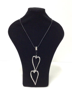 Open Hearts necklace in mottled silvertone metal has two open-hearts that hang on a smooth black  leather-like cord  that does have a lobster claw clap that can add an additional 2" in length however it can easily slip over the head. The hearts can be adjusted to hang at different lengths. 