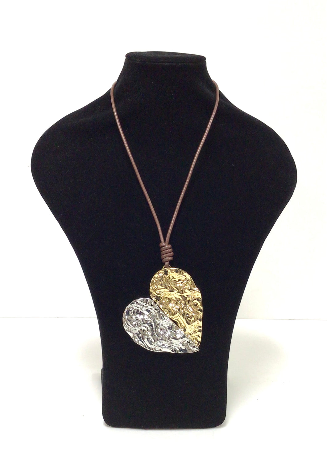 Necklace features a mottled, metal, split heart pendant, that has just a touch of movement and is 3.5Wx3.5H. One side of the split heart is goldtone and the other silvertone, and the heart pendant hangs from a brown 18