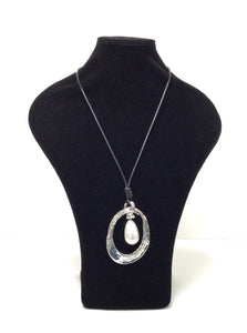 Pendant necklace has an elongated oval in silver-tone, mottled metal. The oval pendant  is accentuated with a large single teardrop-shaped faux pearl that hands in the oval. The pendant is hung on a simple black braided cord that does have a lobster claw clasp that can add an additional 2" in length however it can easily slip over the head.