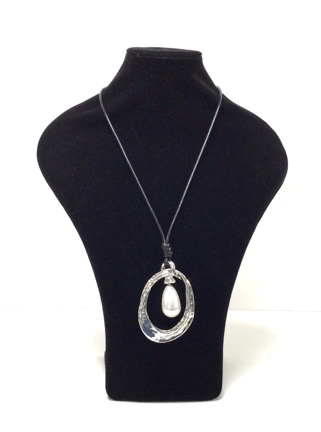 Pendant necklace has an elongated oval in silver-tone, mottled metal. The oval pendant  is accentuated with a large single teardrop-shaped faux pearl that hands in the oval. The pendant is hung on a simple black braided cord that does have a lobster claw clasp that can add an additional 2