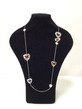 Load image into Gallery viewer, 20&quot; necklace is a fine silvertone chain asymmetrically dotted with lovely silvertone, rose goldtone open hearts, and smaller hearts filled with faux mother of pearl. It does feature a clasp that can add an additional 3&quot; in length but can easily slip over the head. 