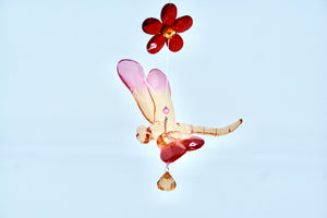 orange and red acrylic dragonfly with 3 red flowers above it