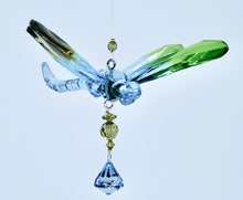 Load image into Gallery viewer, acrylic dragonfly hanging from a fishline that has 3 flowers above it and a crystal like ornament hanging below it
