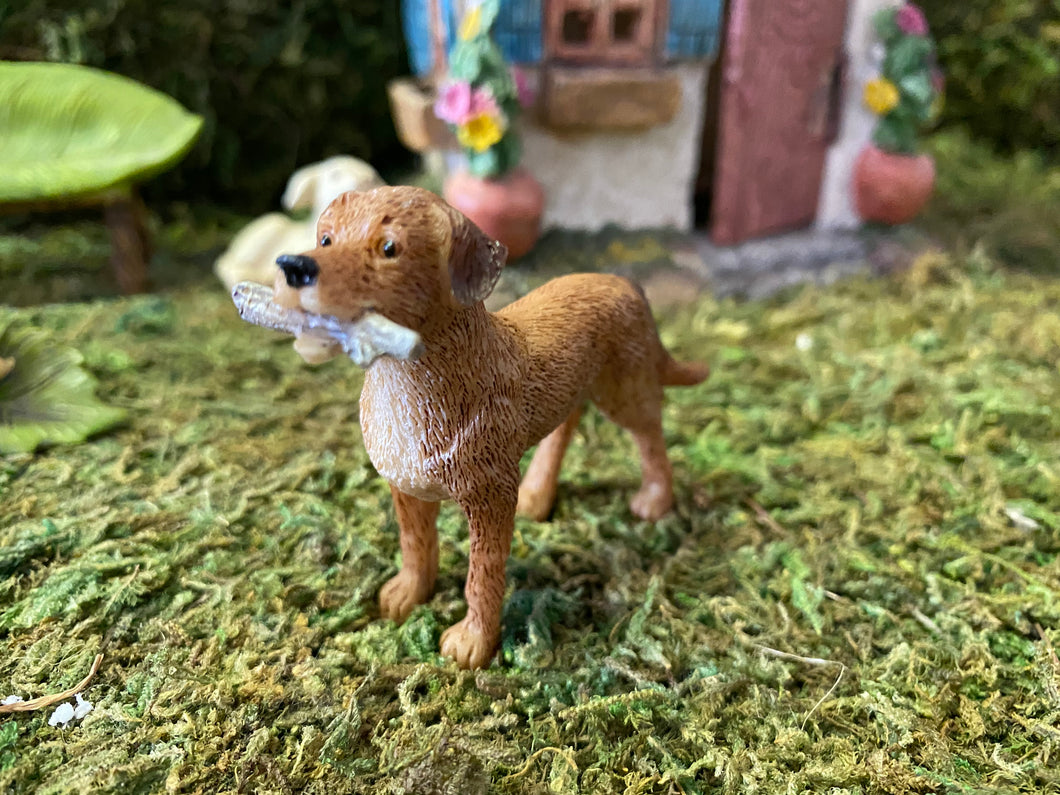 FAIRY GARDEN – RESIN – ‘FETCH’ FAIRY DOG | MG49 | 4.41” T BY 4.25” W BY 4.17” D | ALWAYS READY TO PLAY IN YOUR MINIATURE OR FAIRY GARDEN | LIGHT TAN COAT WITH WHITE CHEST | FINELY DETAILED FUR | WHITE STICK IN ITS MOUTH | FRONT VIEW.