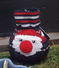Load image into Gallery viewer, This is a waxed amaryllis bulb covered with knit stocking that has a Santa on it.  The top neck of the stocking has 2 red and 2 white stipes around the top.  Santa has a pompom nose attached for greater detail.