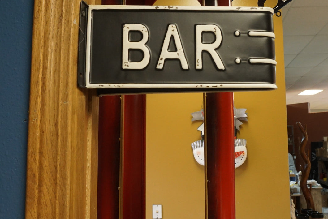 BLACK AND WHITE METAL HANGING BAR SIGN. IT IS A DOUBLE SIDED TRIANGULAR SIGN. IT IS SHOWN ATTACHED TO A DOOR FRAME.