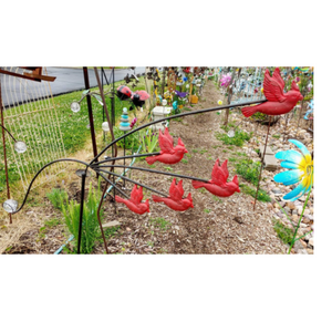5 Red cardinals each on their own stake balancing on a garden stake.  There is a giant glass ball on the other end of the balancing birds that keeps them on the garden stake.