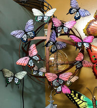 Load image into Gallery viewer, 16 BUTTERFLY PICKS MADE WITH FEATHERS, ATTACHED TO A HANGING METAL BALL WITH A GLOBE HANGING INSIDE IT. THEIR COLORS ARE ORANGE, BLUE, TAUPE, MAGENTA, PURPLE, AND GREEN. THEY ARE 4.5 INCHES HIGH BY 7 INCHES WIDE BY 1” DEEP AND COME WITH A 10” HIGH WIRE PICK. THE BACKGROUND SHOWS A GREEN WALL ON THE LEFT AND A YELLOW WALL BEHIND.