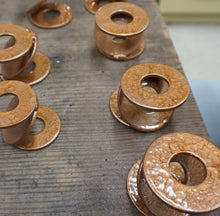 Load image into Gallery viewer, 7 METAL AIR PLANT STANDS. 3 LARGE WASHERS WELDED TOGETHER TO FORM A ‘Z.’ SITTING ON A BOX. BEHIND ARE 6 MORE. ALL ARE PAINTED METALLIC COPPER.