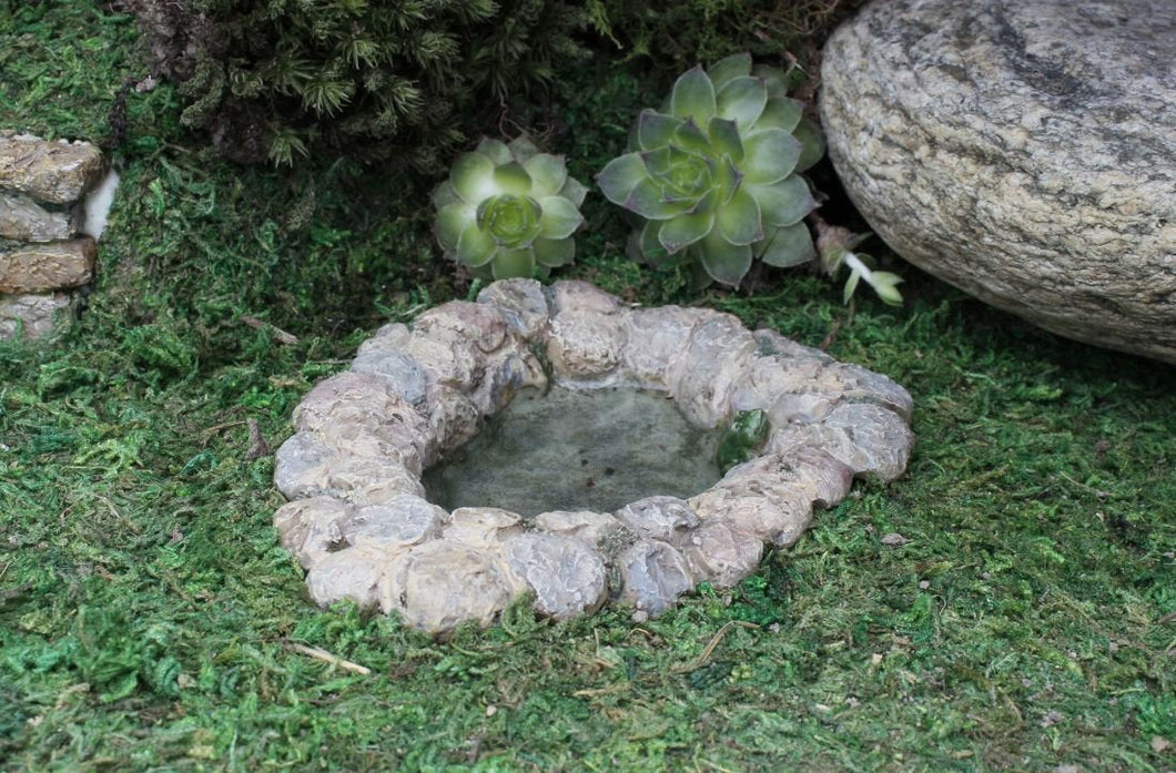 Miniature pond for a fairy garden.  Cobblestone bank.  