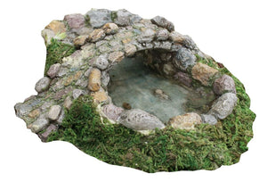 miniature pond with a turtle inside. Cobblestone bridge moss growing around the base.
