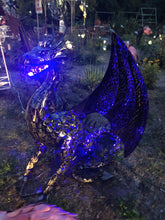 Load image into Gallery viewer, A BLACK POWDER-COATED DRAGON SITTING ON DIRT OUTSIDE. LIT UP BY A BLUE LIGHT. SHOW GARDEN PLANTS, FLAMINGOES, AND WIND SPINNERS IN BACKGROUND.