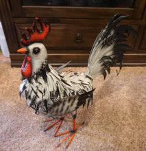 Load image into Gallery viewer, THIS BLACK AND WHITE METAL ROOSTER IS SITTING ON A CEMENT FLOOR, FACING LEFT. IT HAS POWDER-COATED IRON|IS 23 INCHES LONG BY 9 INCHES WIDE BY 23 INCHES HIGH. IT IS FREESTANDING WITH MALLEABLE FEATHERS AND HAS A HAND-PAINTED NATURAL FINISH.