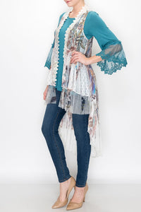 FRONT VIEW OF IVORY LACE JACKET-VEST/LONG LACE HEM | LONGER IN BACK THAN IN FRONT | SIZES S, M, L, PLUS| SCALLOPED, LACE, RUFFLE TRIM/FLORAL AND FEATHERS PRINT | TEAL BLOUSE (LONG LACE CUFFS)/SKINNY-LEGGED BLUE JEANS/TAN HIGH HEELS