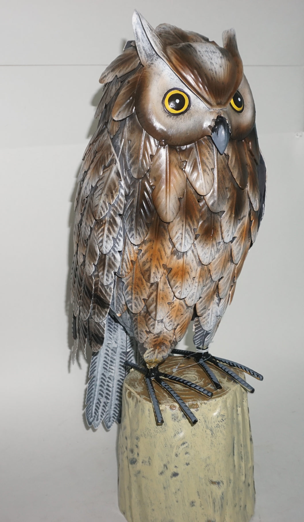 Beautiful Barn owl sitting on a stump.  Brown and silver painted metal statue.  