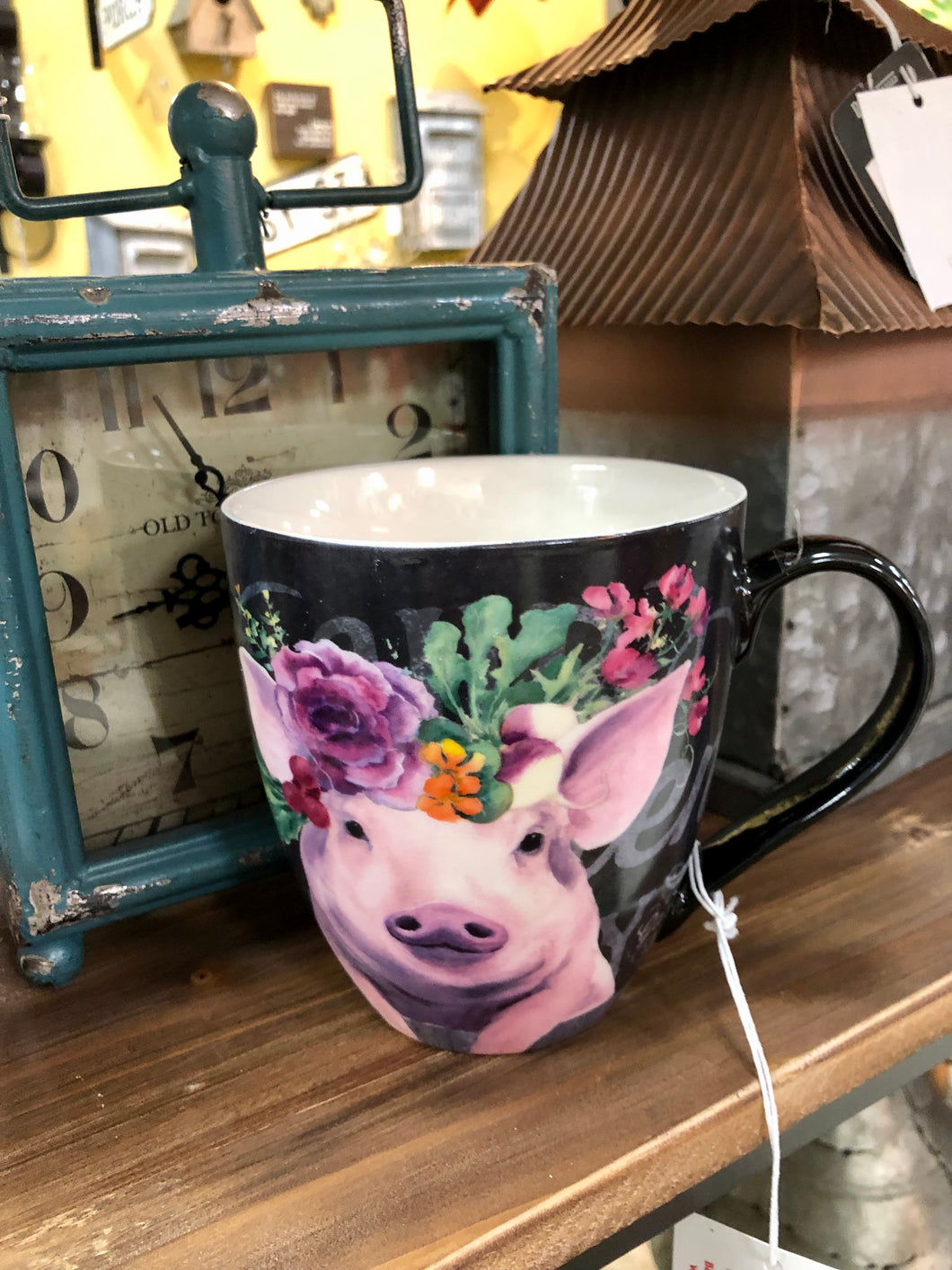 Pink pig wearing a floral tiara on and extra large black ceramic coffee cup
